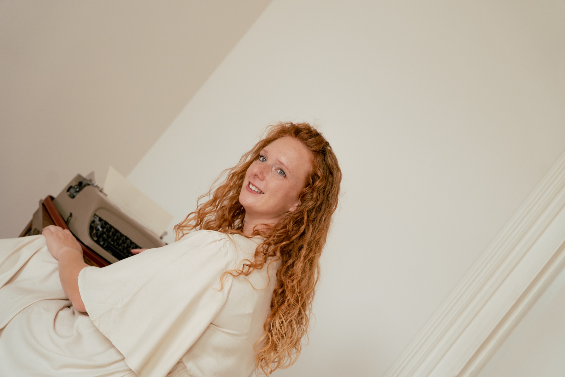 Anita lachend achter haar typemachine